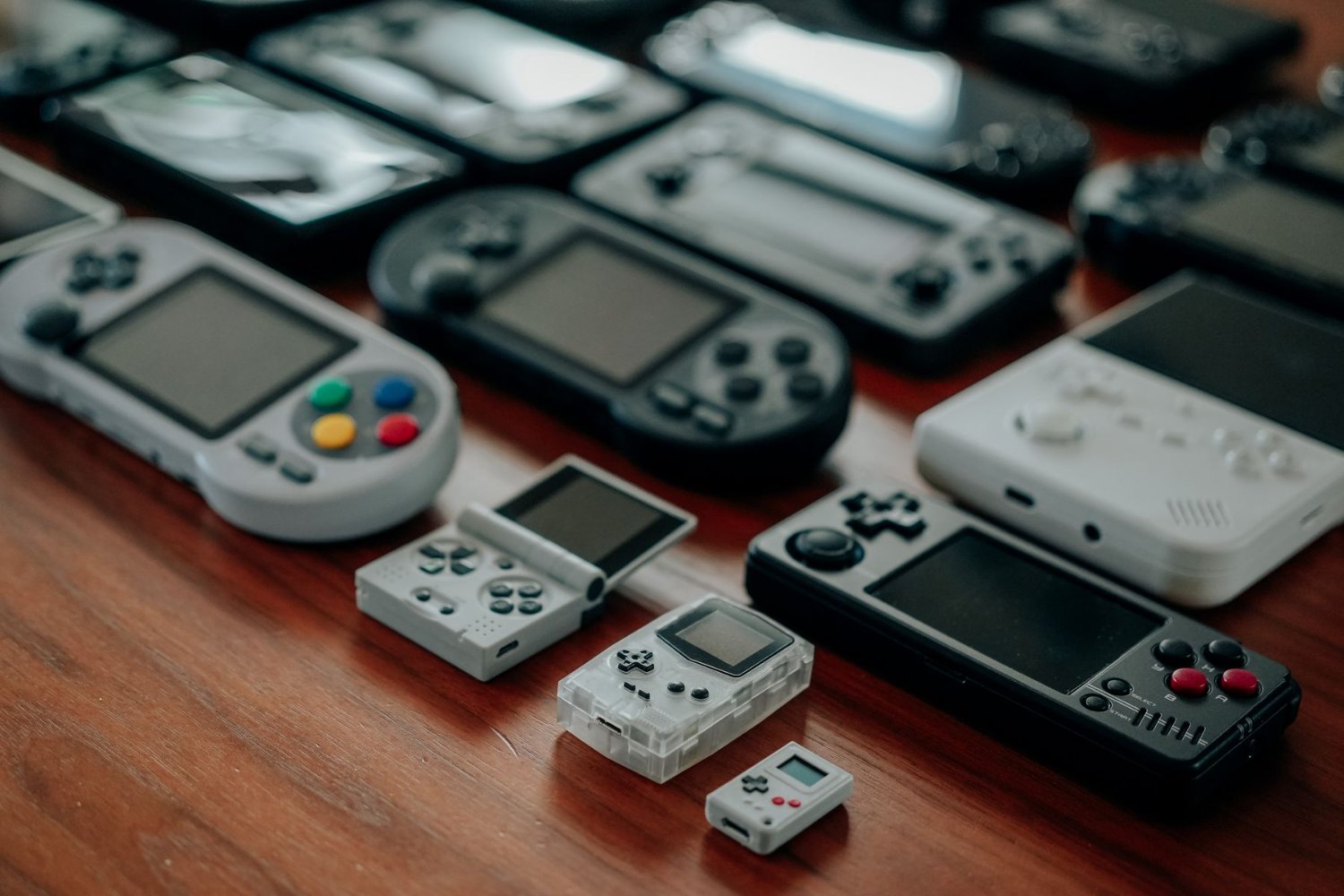 A collection of handheld gaming consoles on a desk